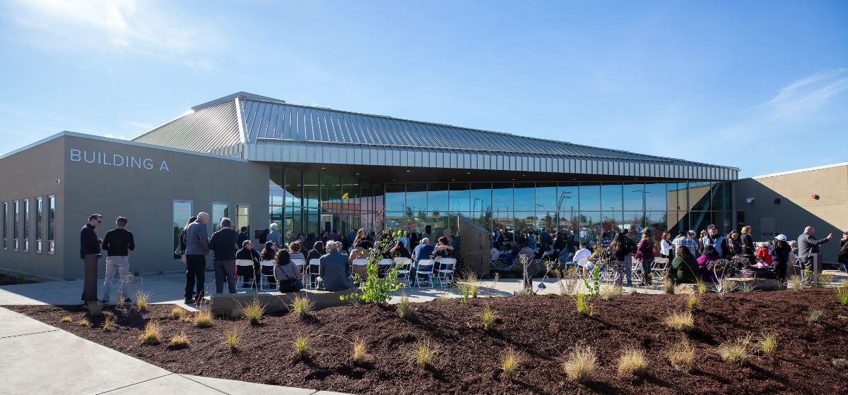 Photo of the new Gavilan College Hollister campus building with people standing in front of it