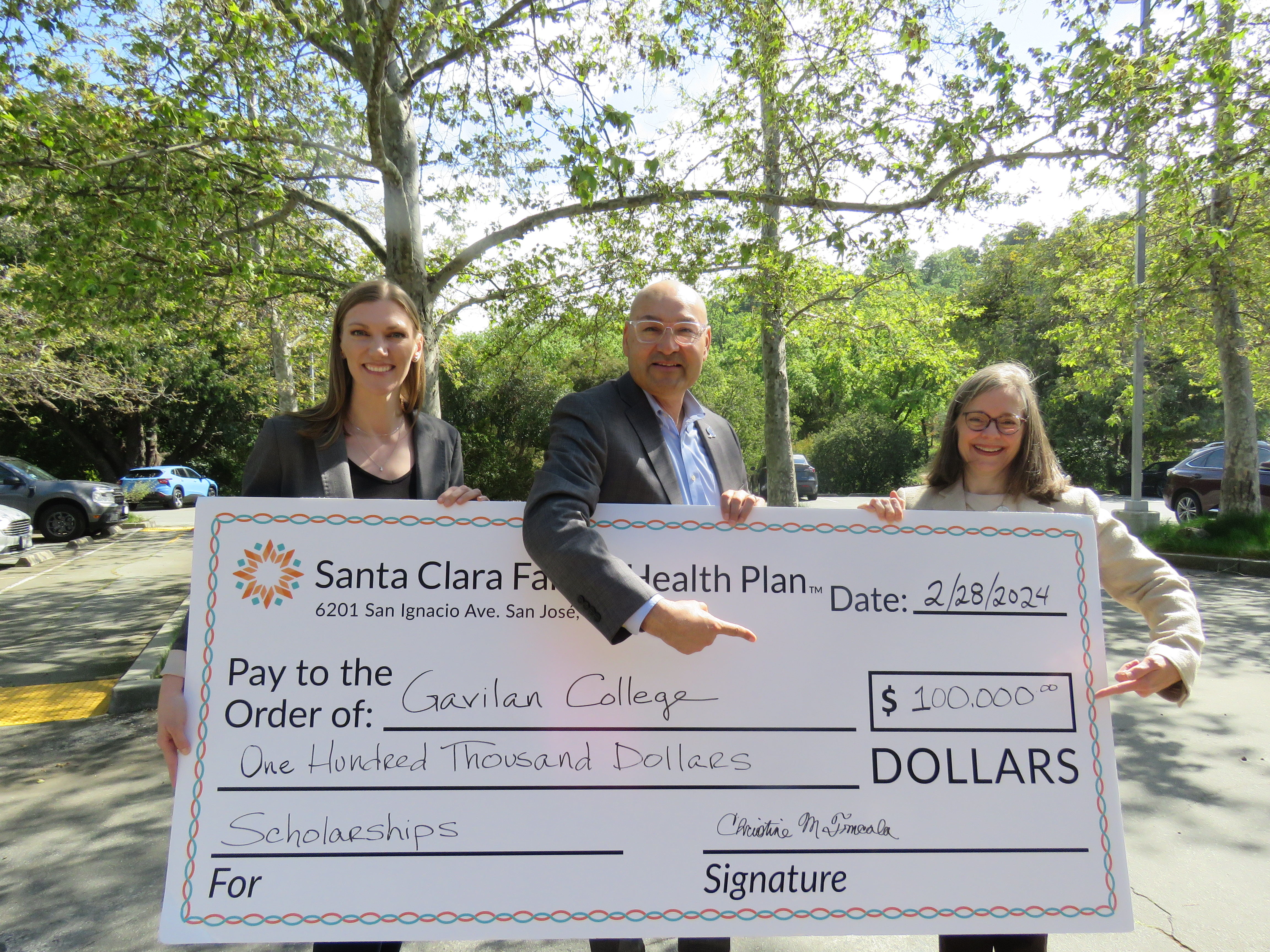 Dr. Pedro Avila accepting check from Christine Tomcala, CEO